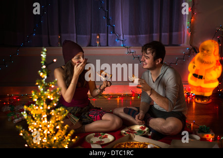 Young couple enjoying pizza at christmas Stock Photo
