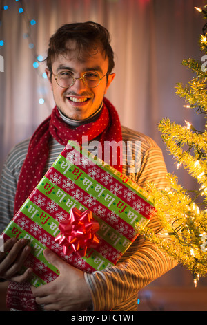 Portrait of young man holding christmas gift Stock Photo