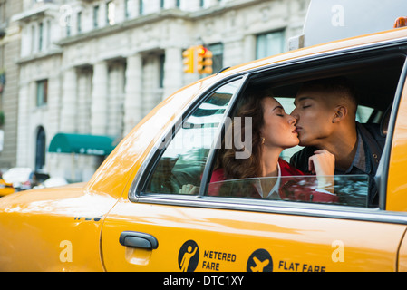Young tourist couple kissing in yellow cab, New York City, USA Stock Photo