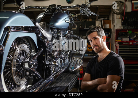 Portrait of mid adult man in motorcycle repair workshop Stock Photo