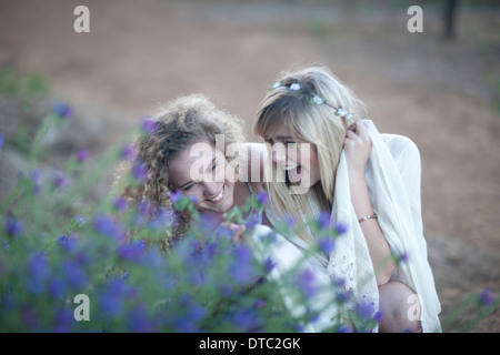 Two teenage girls looking at wildflowers in woodland Stock Photo