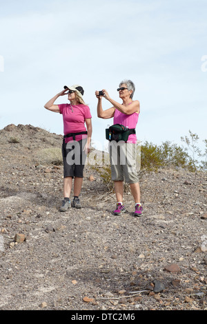 Two senior female hikers looking and photographing view Stock Photo