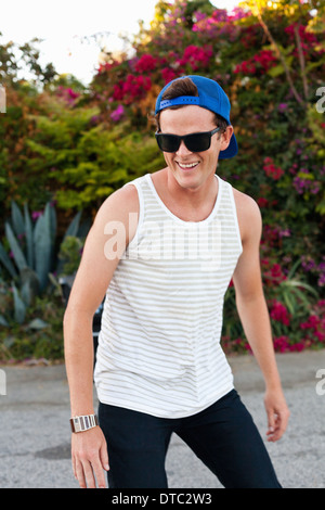 Young man skateboarding along sidewalk Stock Photo