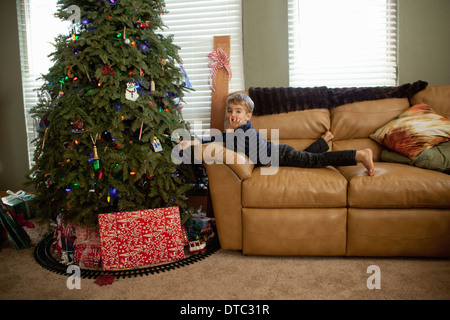 Excited male toddler looking at decorations on xmas tree Stock Photo
