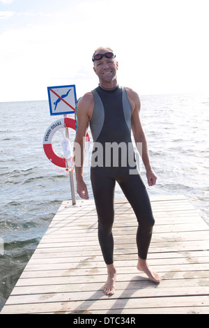 Portrait of man in diving suit standing on pier Stock Photo