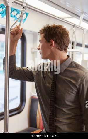 Mid adult businessman staring out of train carriage window Stock Photo