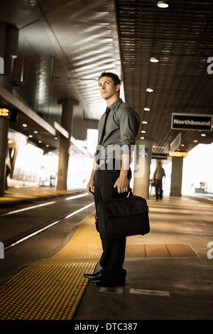 Mid adult businessman waiting for train at station Stock Photo