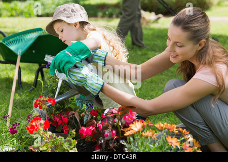 Mother and daughter watering plants at garden Stock Photo