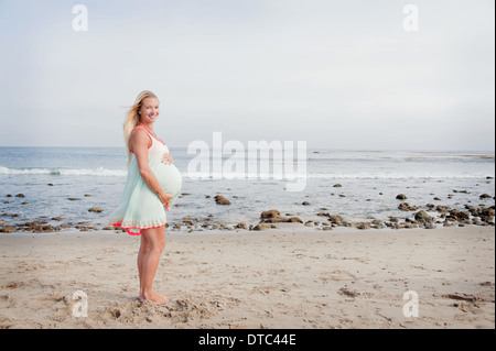 Portrait of pregnant young woman on beach Stock Photo