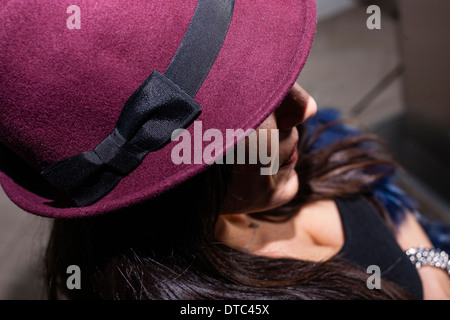 Cropped shot of mid adult woman in purple hat Stock Photo