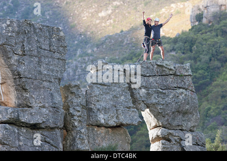 Young rock climbing couple celebrating on rock formation