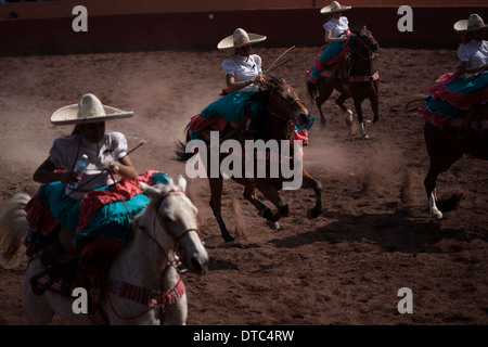 Escaramuzas ride their horses in an Escaramuza fair in the Lienzo Charros el Penon, Mexico City Stock Photo