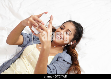 Young woman listening to music in bedroom Stock Photo