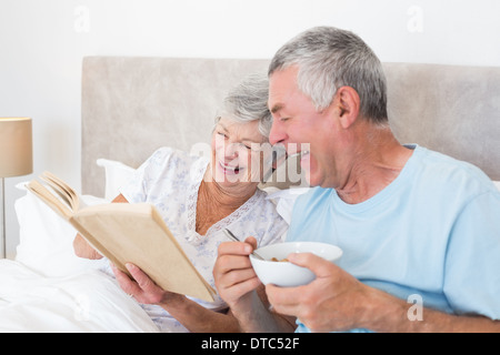 Senior couple reading book in bed Stock Photo