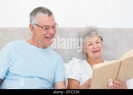 Senior couple reading book together in bed Stock Photo