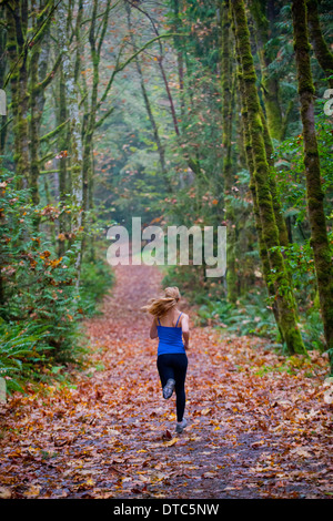 Girl jogging in forest Stock Photo