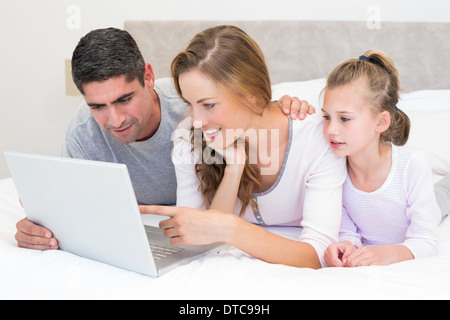 Family using laptop in bed Stock Photo