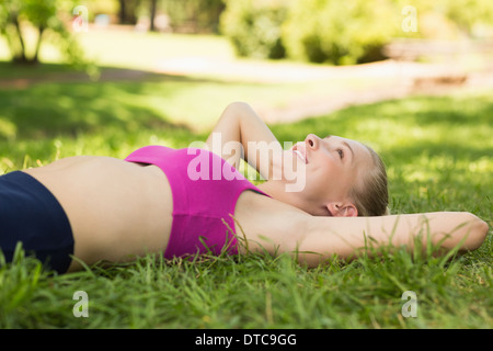 Relaxed woman lying on grass in park Stock Photo - Alamy
