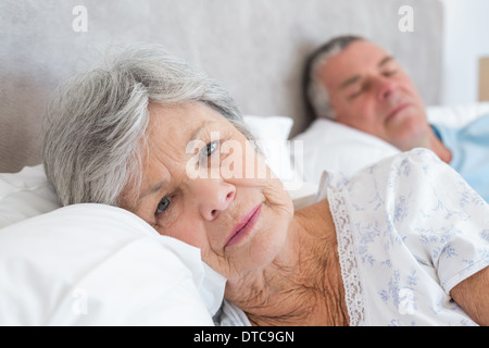 Senior woman lying with man in background Stock Photo