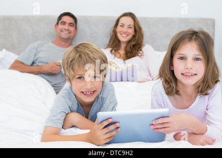 Smiling siblings holding digital tablet Stock Photo