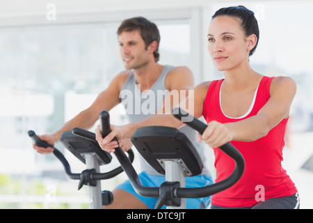 Determined couple working out at spinning class in gym Stock Photo