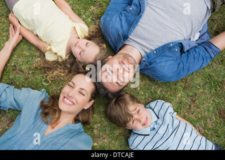 Happy parents and kids lying at park Stock Photo