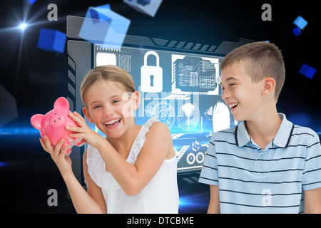 Composite image of smiling young girl holding piggy bank Stock Photo