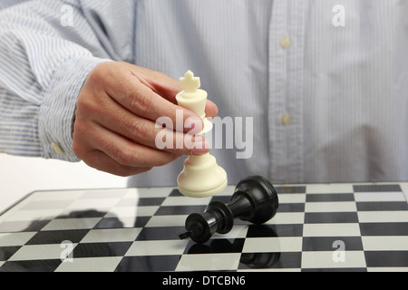 Male hand with a chess king on chessboard Stock Photo