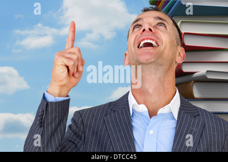 Composite image of cheerful businessman pointing upward Stock Photo