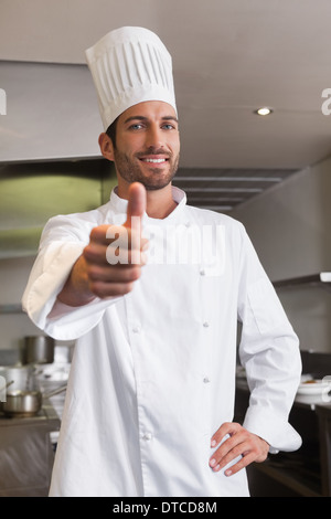 Happy young chef looking at camera showing thumb up Stock Photo