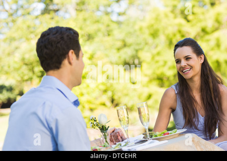 Couple with champagne flutes sitting at an outdoor cafÃ© Stock Photo