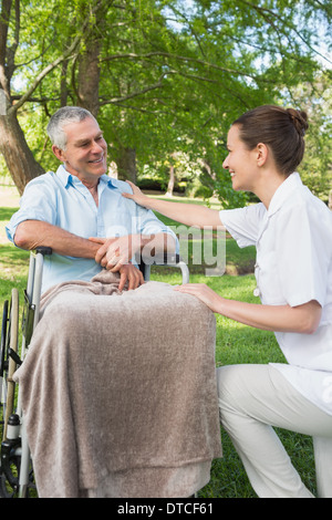 Woman with father sitting in wheel chair at park Stock Photo