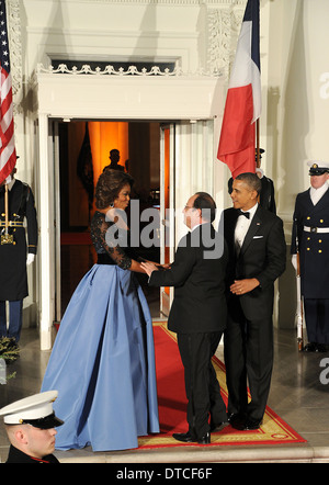 US first lady Michelle Obama welcomes French President Francois Hollande as President Barack Obama looks on the North Portico of the White House February 11, 2014 in Washington, D.C. Stock Photo