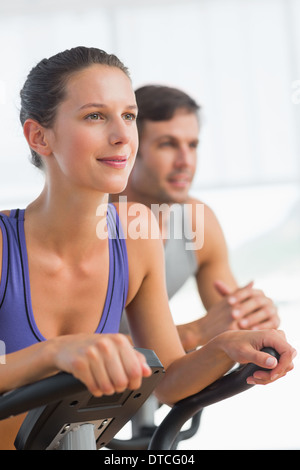 Smiling young couple working out at spinning class Stock Photo