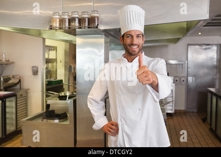 Smiling young chef looking at camera showing thumb up Stock Photo