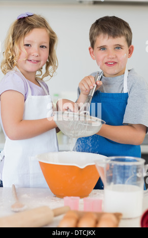 Children baking cookies together in kitchen Stock Photo