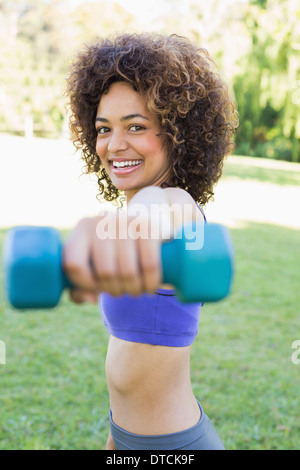 Smiling woman lifting hands weights Stock Photo