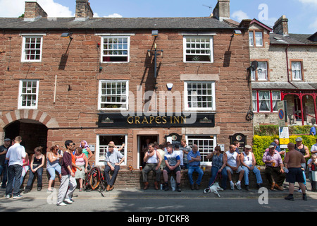 People drinking alcohol outside the Grapes Inn at Appleby-in-Westmorland, Cumbria, England, U.K. Stock Photo