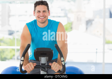 Smiling young man working out at spinning class Stock Photo