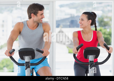 Couple working out at spinning class in bright gym Stock Photo