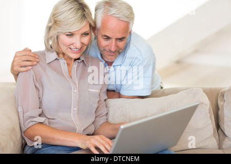Mature couple using laptop on sofa Stock Photo