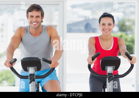Smiling young couple working out at spinning class Stock Photo