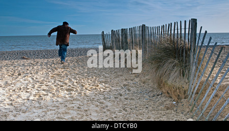 older man running on beach Stock Photo