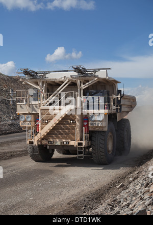 Massive white hitatchi dump truck driving in a large open cast copper and gold mine in Africa Stock Photo