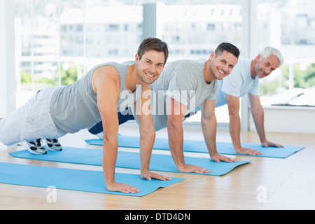 Fit men doing push ups at gym Stock Photo