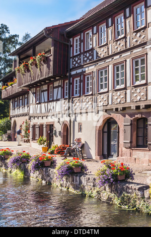 half-timbered house on the banks of a flower decked creek in the historic part of schiltach, black forest, baden-wuerttemberg Stock Photo