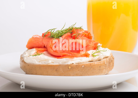 Delicious freshly made bagel with cream cheese, smoked salmon, dill and served with fresh orange juice