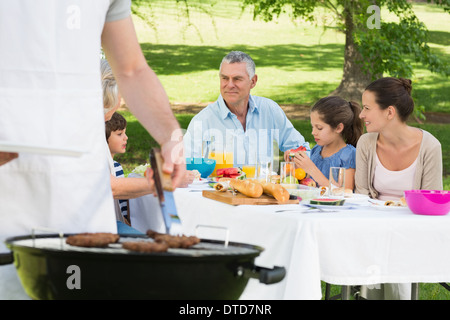 Barbecue grill with extended family having lunch in park Stock Photo