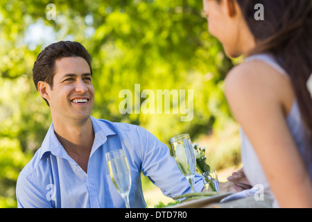 Couple with champagne flutes sitting at an outdoor cafÃ© Stock Photo