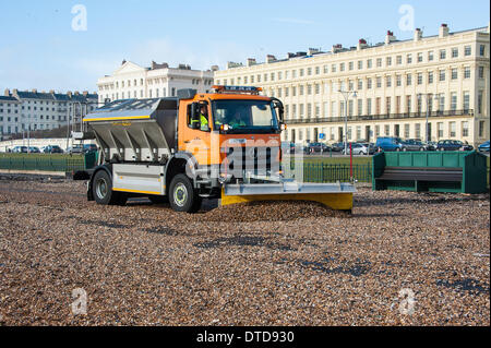 Brighton, East Sussex, UK. 15th Feb, 2014. After yet another night of violent storms and high windsin Brighton the promenade is awash with shingle and the council workers are desperately trying to clear a path for the course of tomorrow's Brighton Half Marathon. Credit:  Julia Claxton/Alamy Live News Stock Photo